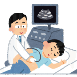 医療現場で腹部や頸動脈などのエコー検査を行っている様子。プローブ操作やモニター画像を確認する技師・医師の手元が映っている。