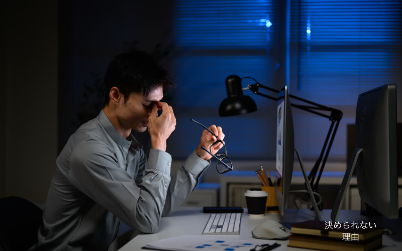 腸や睡眠の乱れによって判断力が低下する状態を象徴する、夜のオフィスで考え込む人物のイメージ