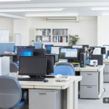 職場でまだ問題になっていない小さな変化や違和感を象徴する、静かで落ち着いたオフィスの風景