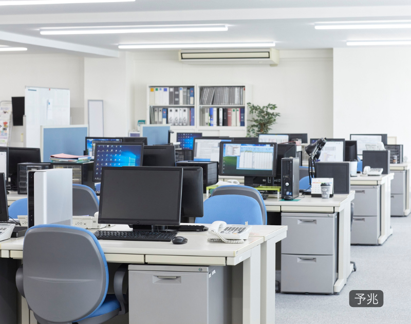 職場でまだ問題になっていない小さな変化や違和感を象徴する、静かで落ち着いたオフィスの風景