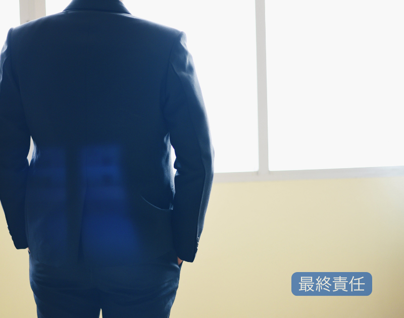 会社の最終責任を担う社長が、静かに判断と向き合う姿を象徴したオフィスでの後ろ姿